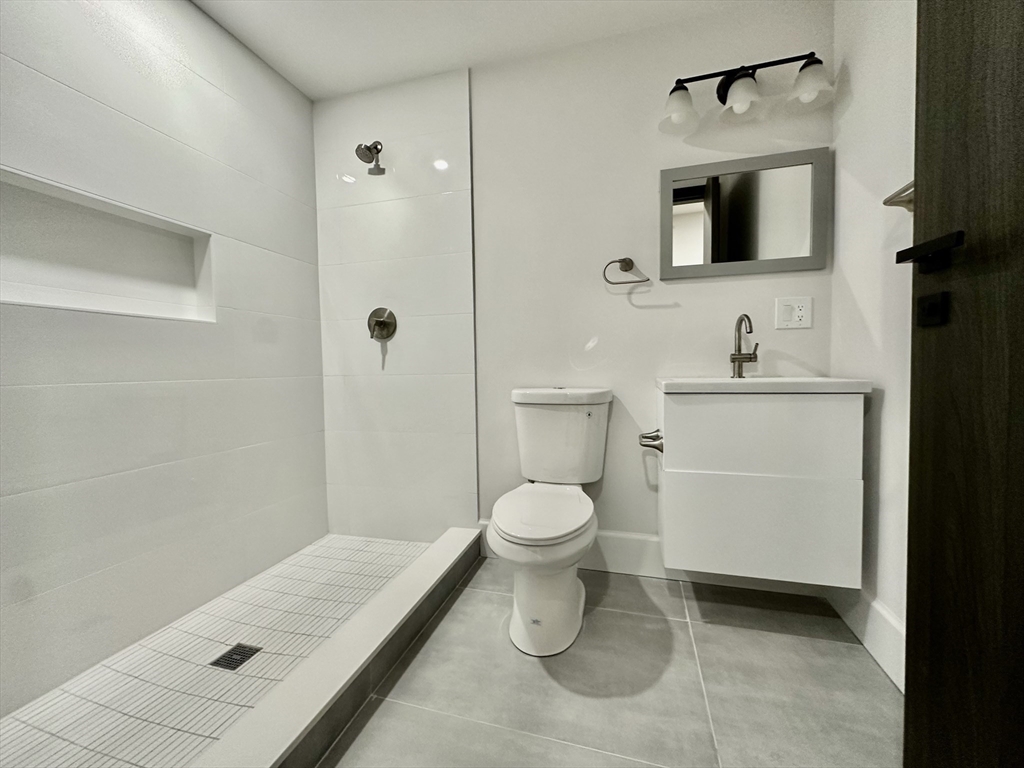 100 Mt Pleasant Avenue, Unit 4 Boston, MA 02119 - Photo 12 of 15 a bathroom with a toilet sink and shower