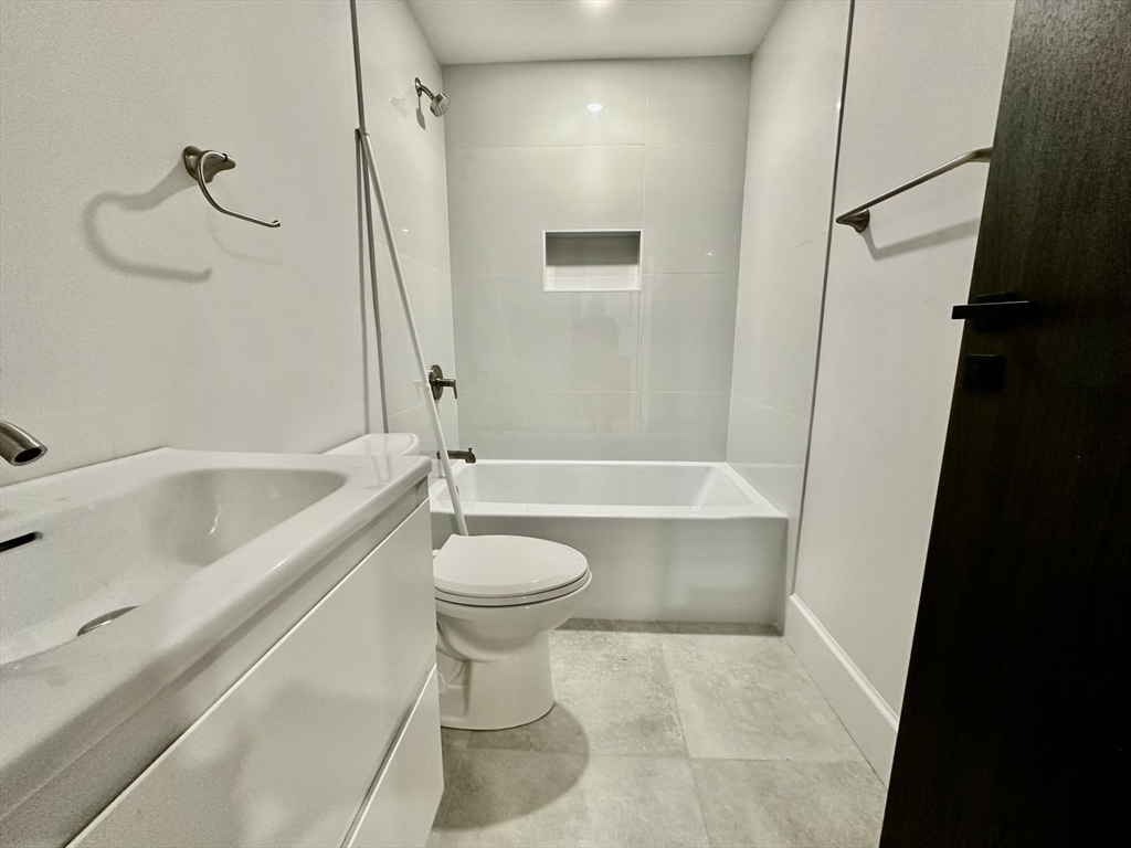 100 Mt Pleasant Avenue, Unit 4 Boston, MA 02119 - Photo 13 of 15 a bathroom with a bathtub a toilet and a shower