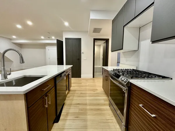 a kitchen with stainless steel appliances a sink stove and cabinets