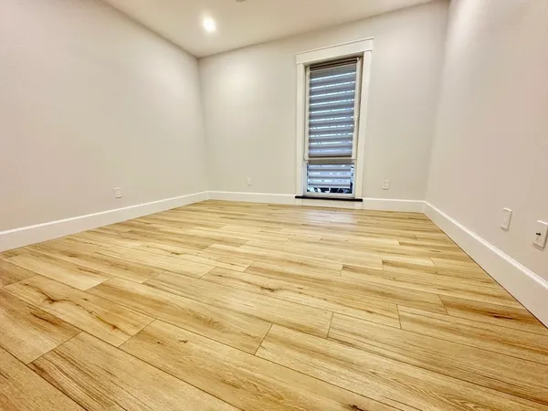 a view of a room with wooden floor and white walls
