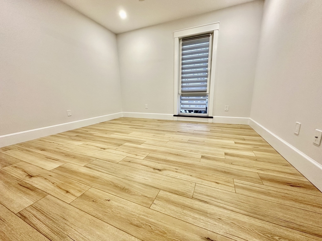 100 Mt Pleasant Avenue, Unit 4 Boston, MA 02119 - Photo 5 of 15 a view of a room with wooden floor and white walls