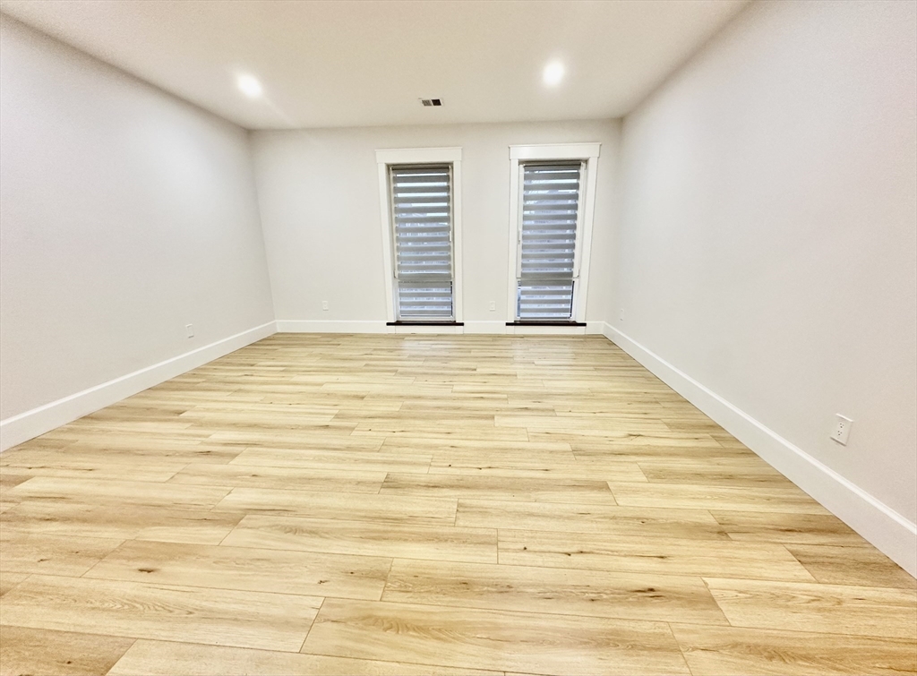 100 Mt Pleasant Avenue, Unit 4 Boston, MA 02119 - Photo 6 of 15 a view of an empty room with wooden floor and a window