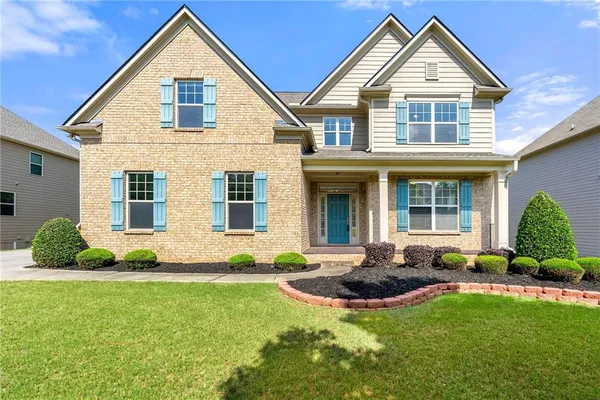 a front view of a house with a yard and outdoor seating