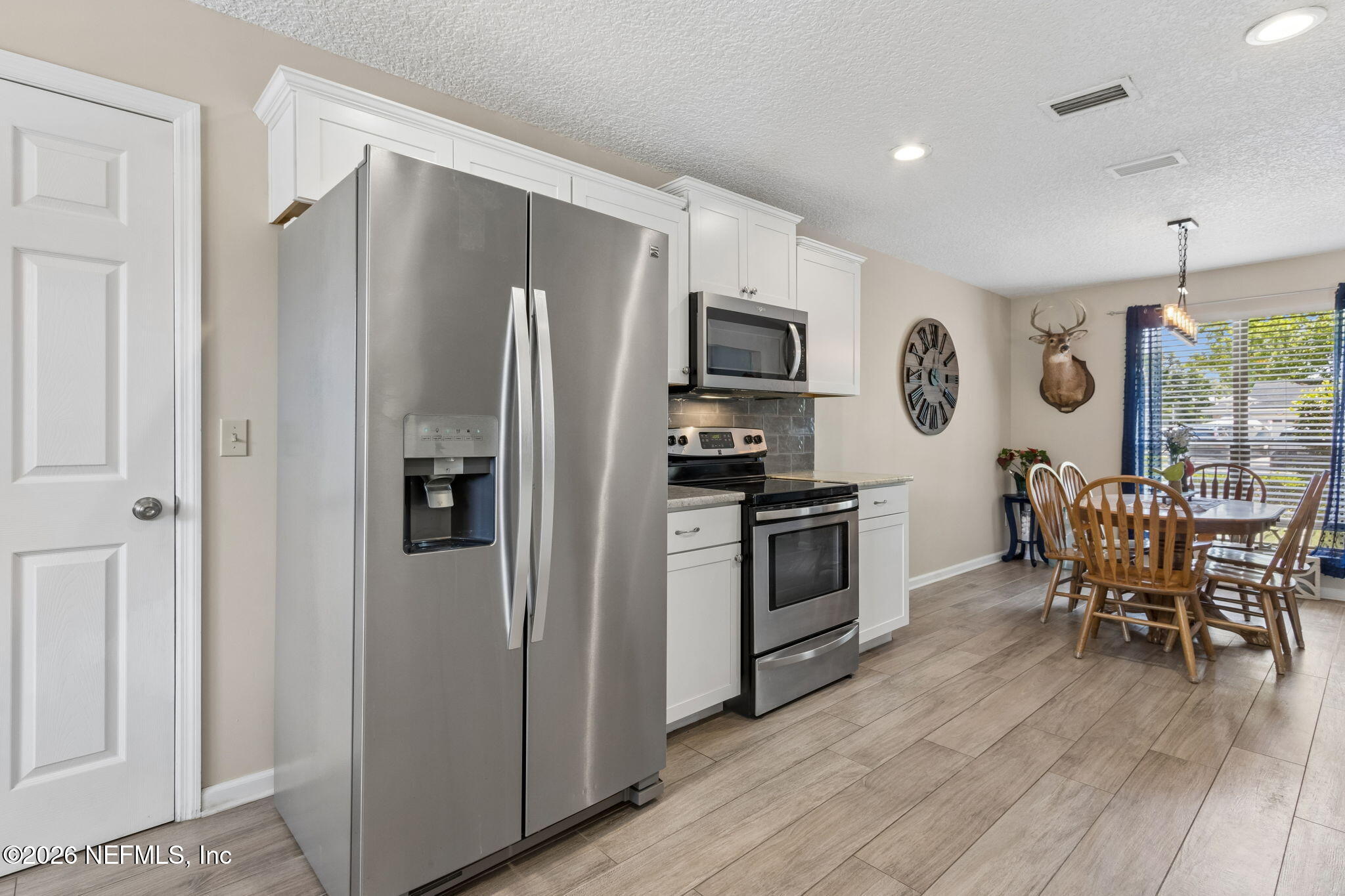 3194 Creighton Landing Road Fleming Island, FL 32003 - Photo 15 of 31 a kitchen with stainless steel appliances a refrigerator stove microwave and cabinets
