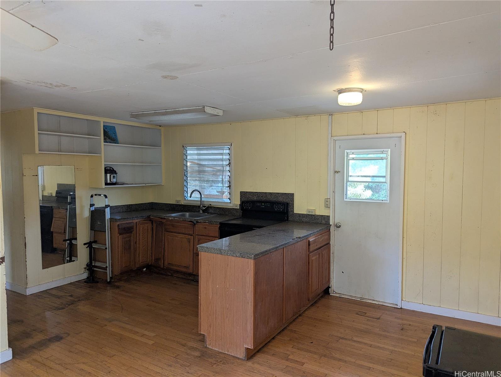85-775A Waianae Valley Road Waianae, HI 96792 - Photo 13 of 25 a kitchen with stainless steel appliances granite countertop a sink stove and wooden floor