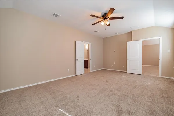 an empty room with closet and ceiling fan
