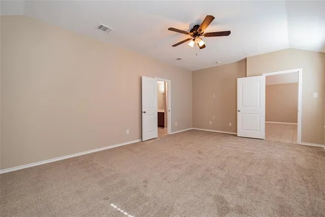 an empty room with closet and ceiling fan