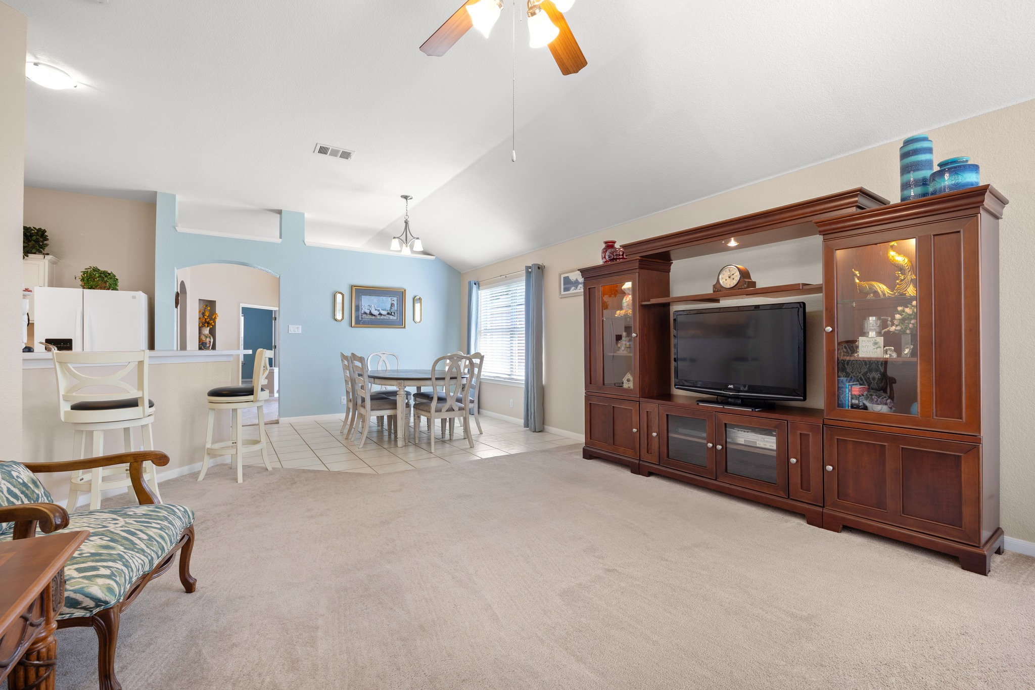 1108 Springbrook Road Pflugerville, TX 78660 - Photo 12 of 37 An inviting open-concept living space features vaulted ceilings and a dining area connected to the kitchen.