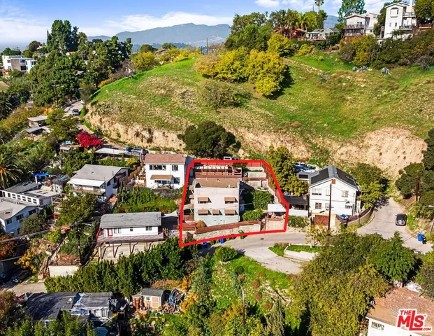 an aerial view of residential houses with outdoor space and trees