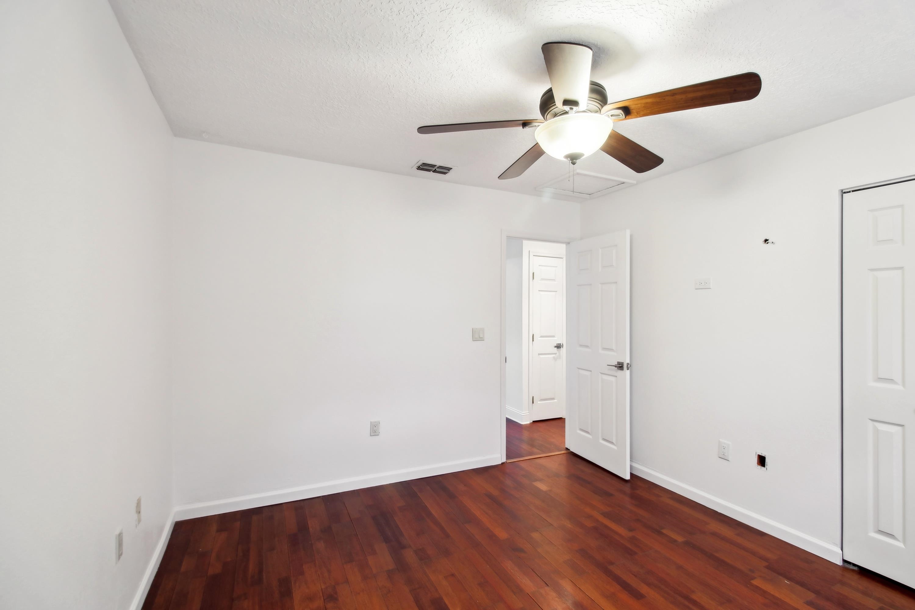 240 Jasmine Road St. Augustine, FL 32086 - Photo 20 of 30 an empty room with wooden floor ceiling fan and window