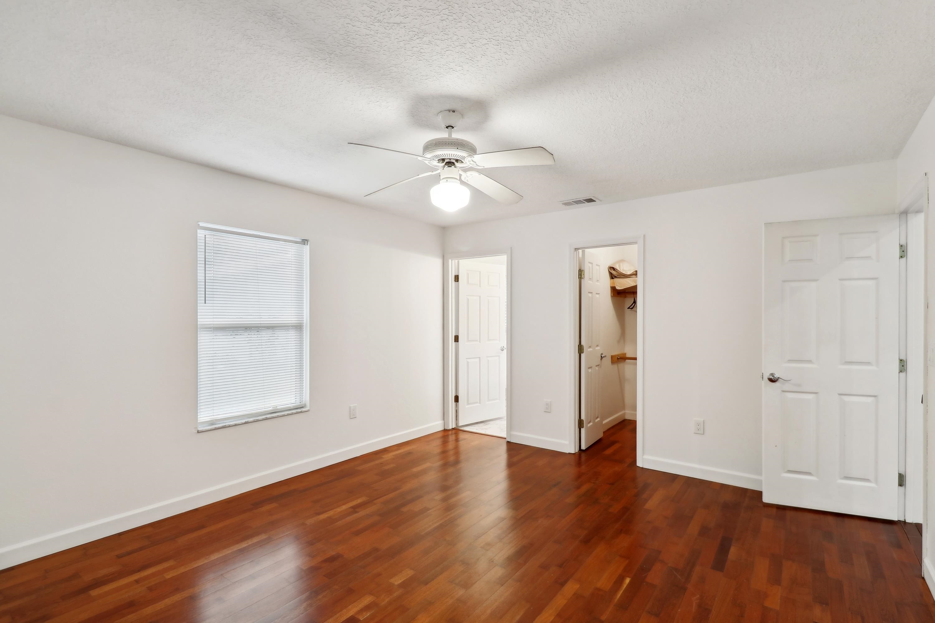 240 Jasmine Road St. Augustine, FL 32086 - Photo 24 of 30 an empty room with wooden floor ceiling fan and windows