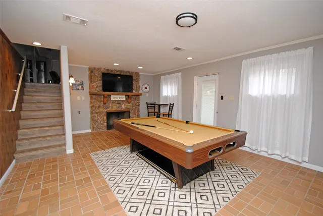 a room with pool table and windows