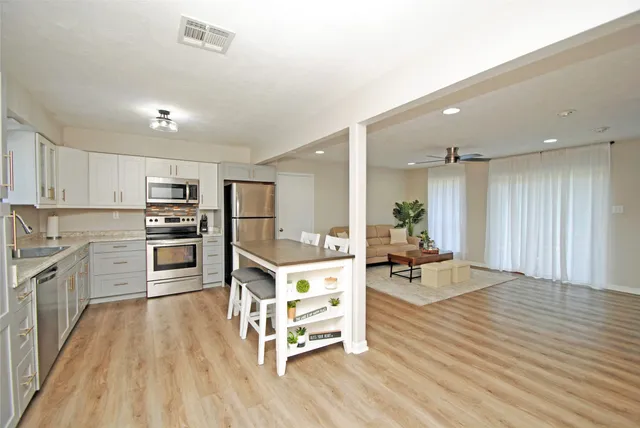 a living room with furniture and kitchen view