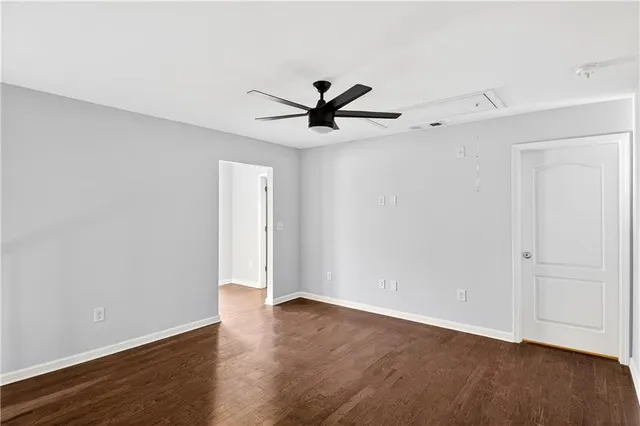 a view of a room with wooden floor and a ceiling fan