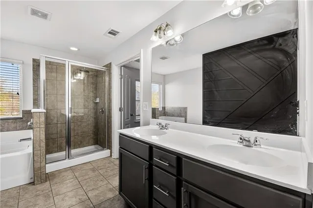 a bathroom with a double vanity sink mirror and shower