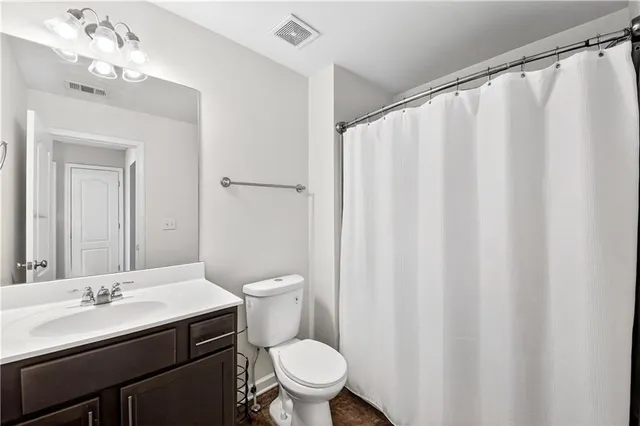 a bathroom with a sink a toilet and shower curtain