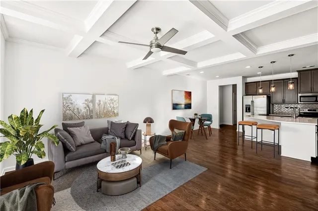a living room with furniture kitchen view and a potted plant