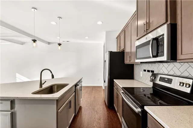 a kitchen with stainless steel appliances granite countertop a sink a stove and a refrigerator