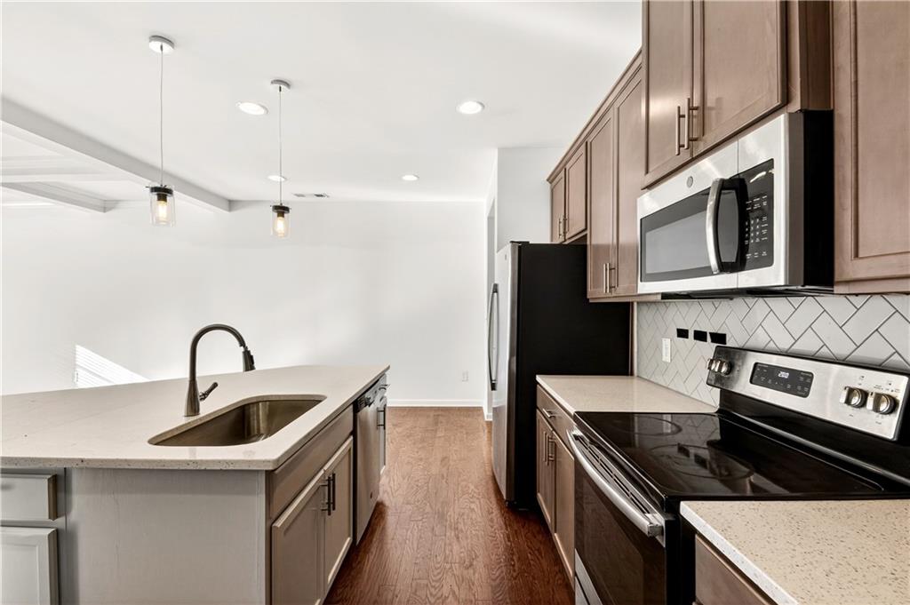 7789 Rutgers Circle Fairburn, GA 30213 - Photo 10 of 39 a kitchen with stainless steel appliances granite countertop a sink a stove and a refrigerator