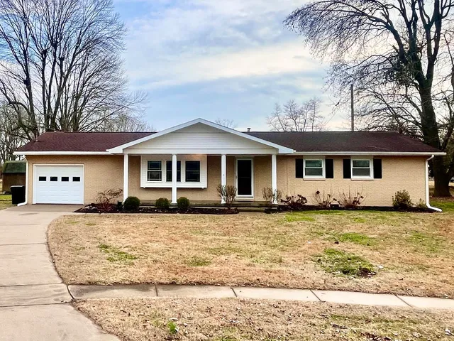 a front view of a house with a yard and trees