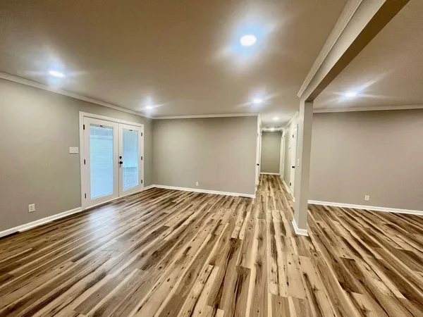 a view of an empty room with wooden floor