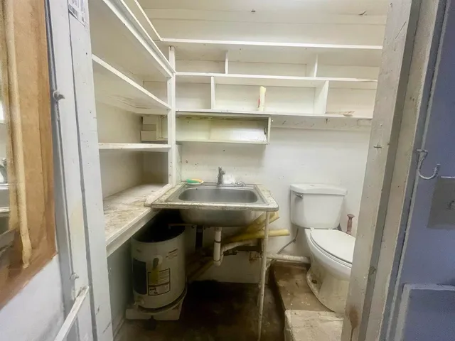 a bathroom with a sink a toilet a rug and a window