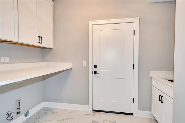 a view of cabinets and utility room with closet