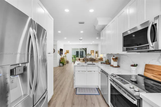 a kitchen with a sink stainless steel appliances and cabinets