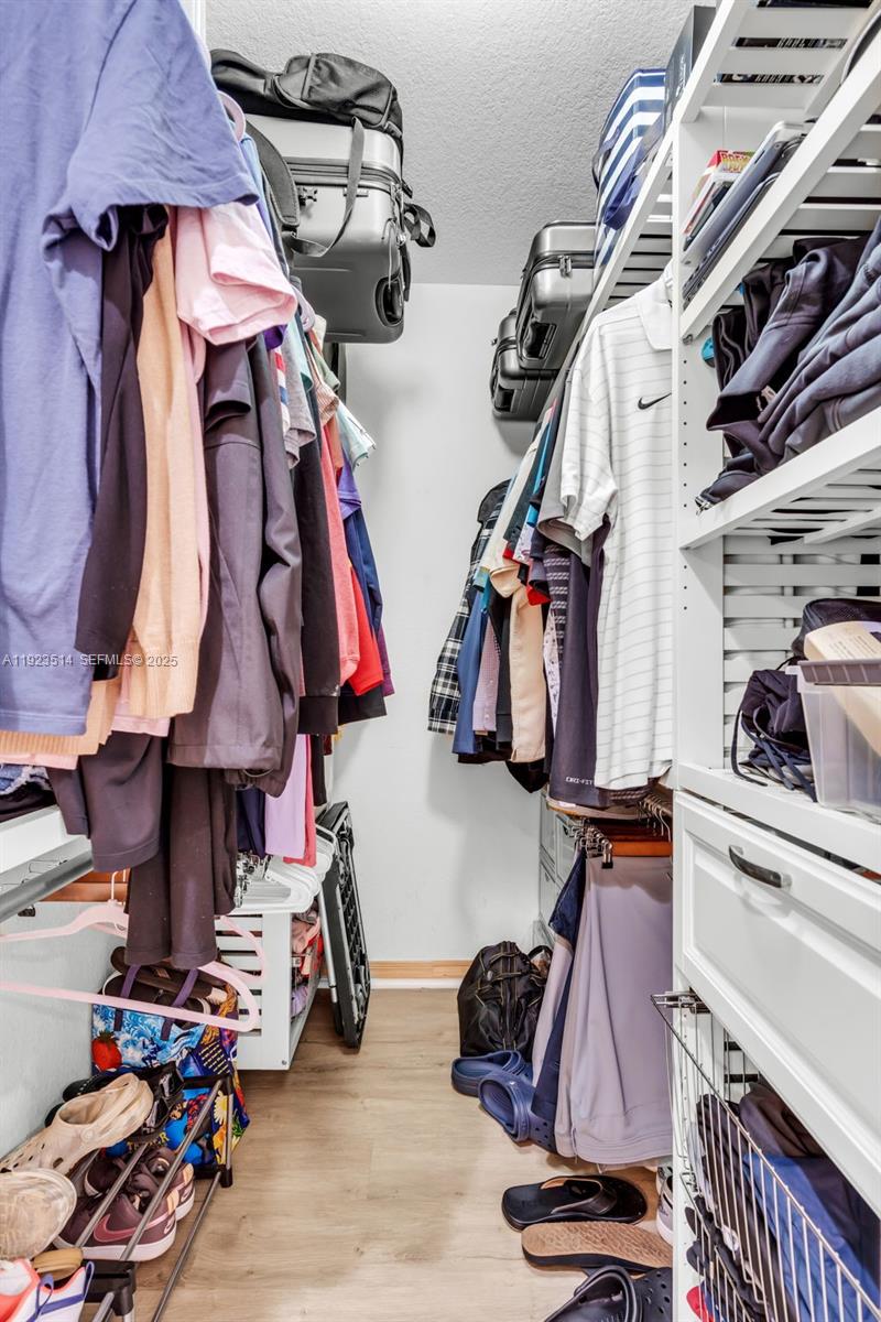12430 Southwest 50th Street, Unit 109 Miramar, FL 33027 - Photo 23 of 28 a view of walk in closet with clothes and shoes