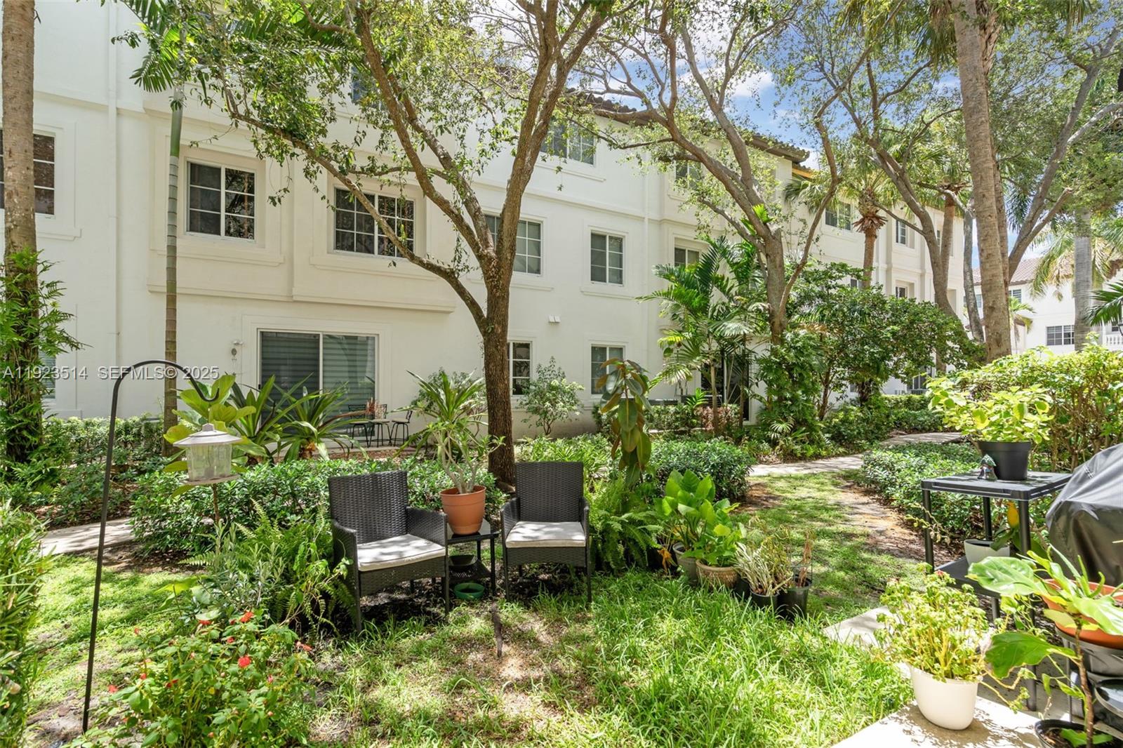 12430 Southwest 50th Street, Unit 109 Miramar, FL 33027 - Photo 24 of 28 a view of a house with backyard sitting area and garden