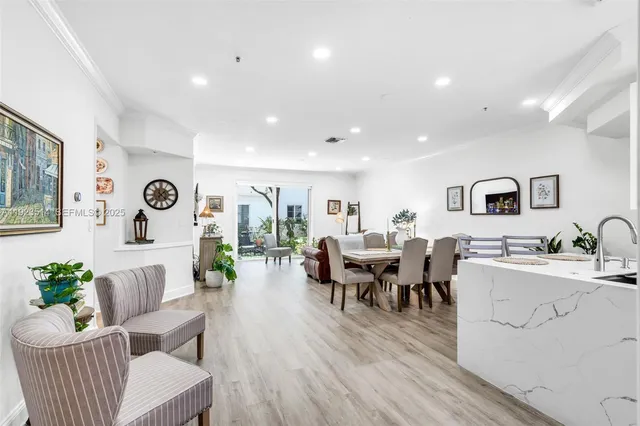 a living room with lots of furniture and view of kitchen