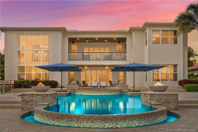 a view of a house with swimming pool and sitting area