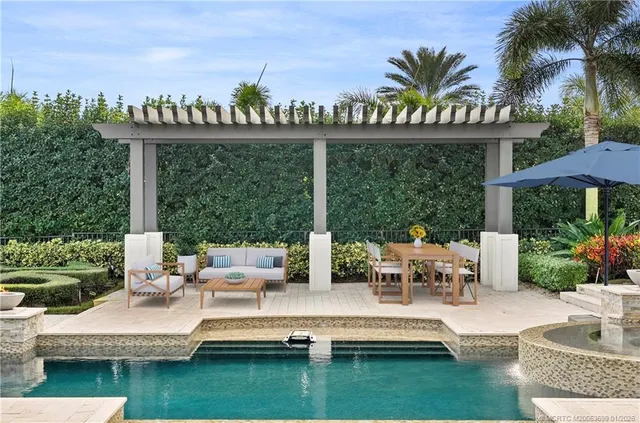 a view of a house with swimming pool and sitting area