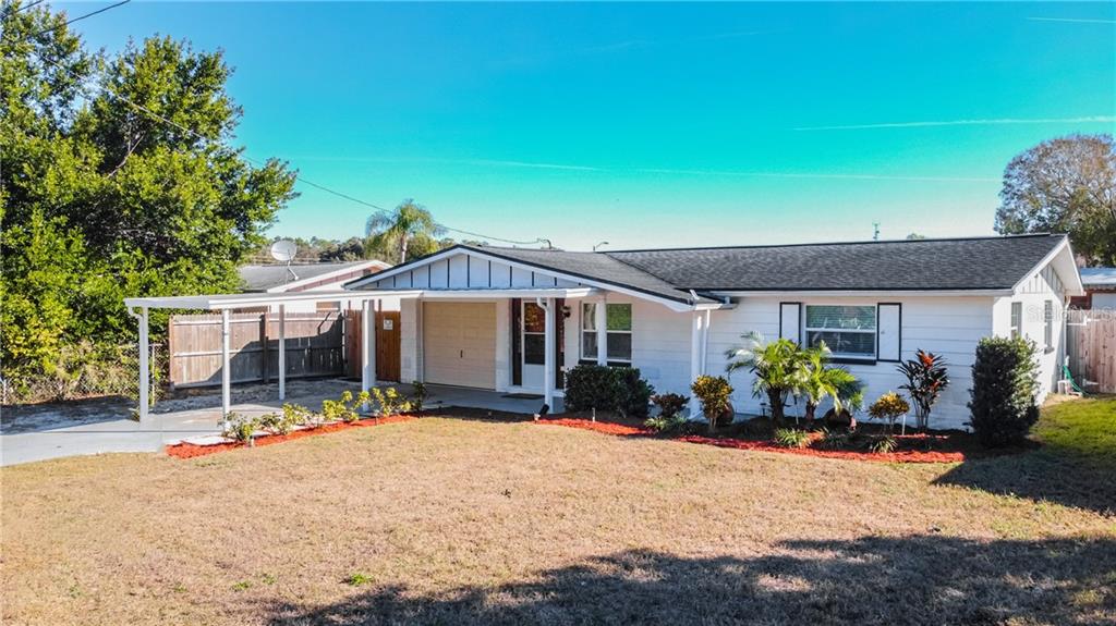 5060 Cougar Loop Holiday, FL 34690 - Photo 1 of 1 a front view of a house with a yard and potted plants