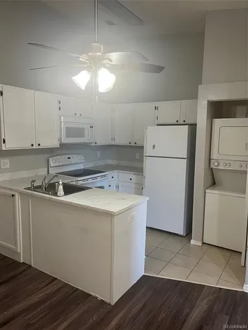 a kitchen with a sink a stove a refrigerator and white cabinets
