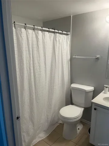 a white toilet sitting next to a shower curtain