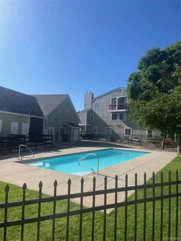 a view of swimming pool with seating area and trees