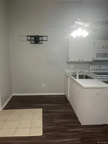 a kitchen with a sink a refrigerator and chandelier