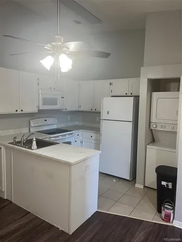 a kitchen with a sink a refrigerator and cabinets