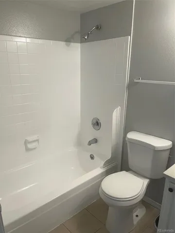 a white toilet sitting next to a bath tub and a shower