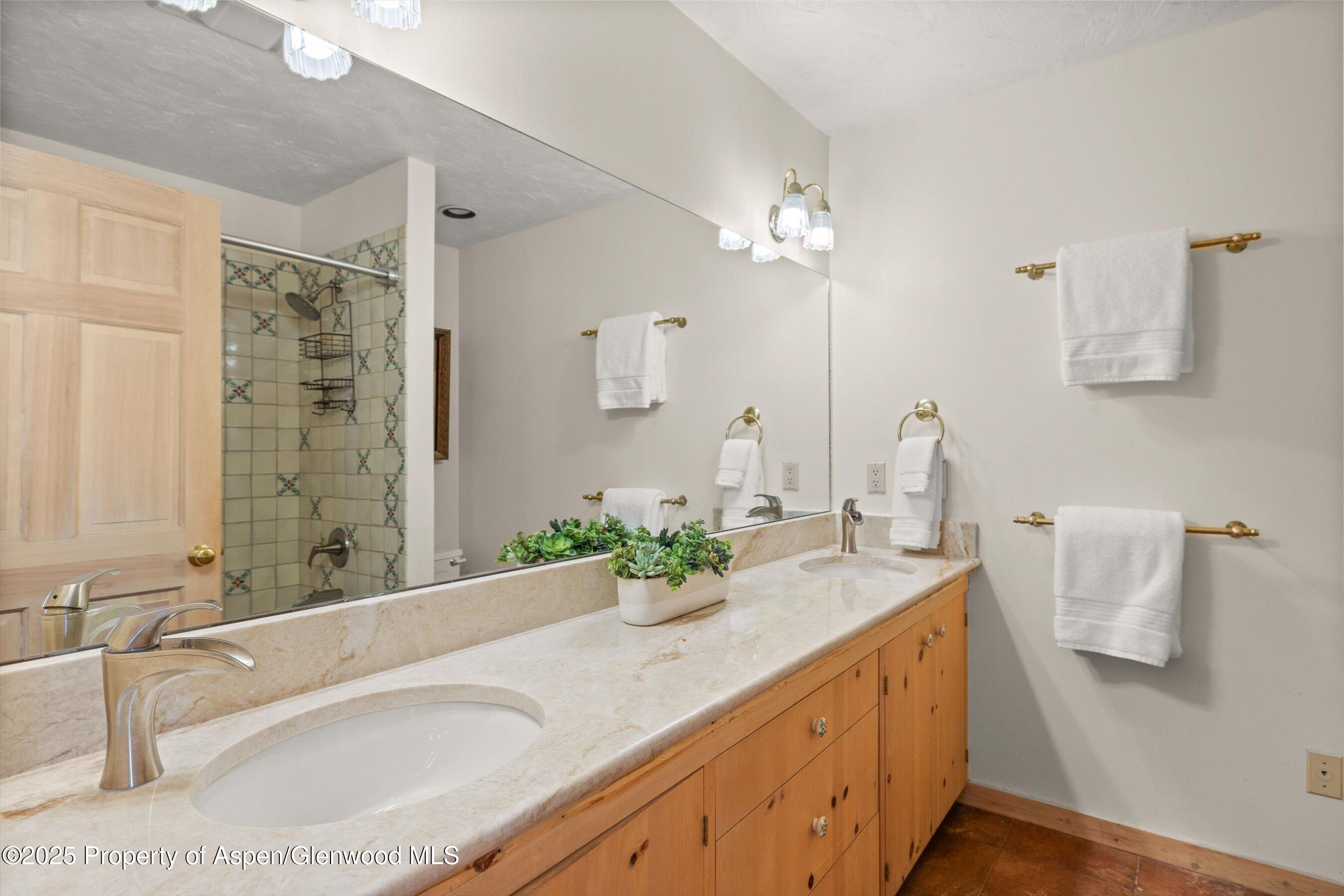 818 Faraway Road Snowmass Village, CO 81615 - Photo 13 of 24 a bathroom with a granite countertop sink a mirror and a bathtub