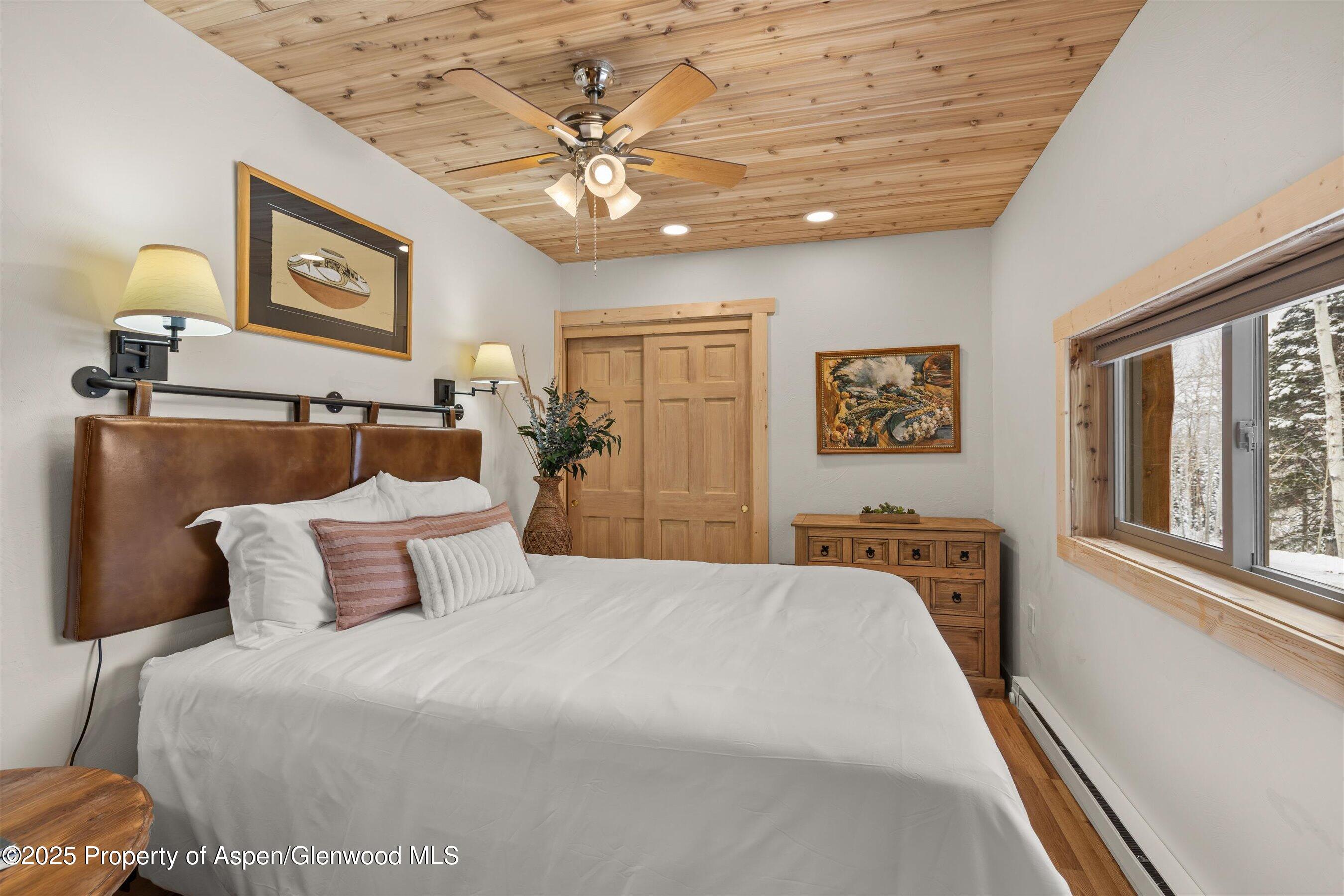 818 Faraway Road Snowmass Village, CO 81615 - Photo 20 of 24 a bedroom with a large bed and a chandelier