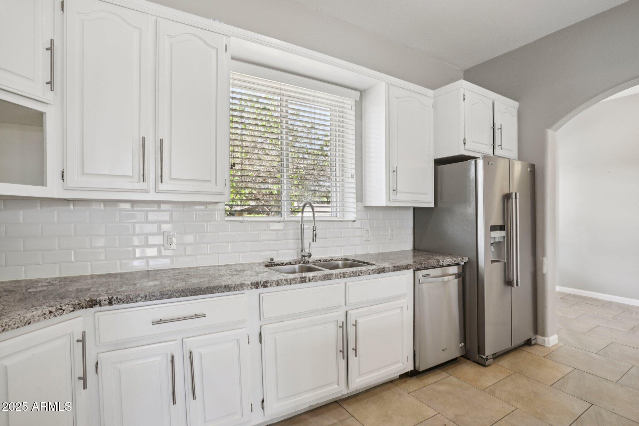 702 West Why Worry Lane Phoenix, AZ 85021 - Photo 8 of 46 a kitchen with stainless steel appliances granite countertop white cabinets and a refrigerator