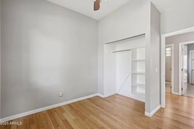 a view of a hallway with wooden floor and a bathroom