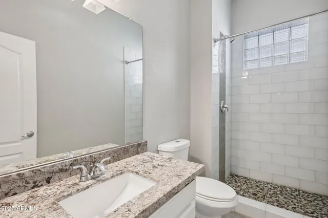 a view of a livingroom with a chandelier fan and windows