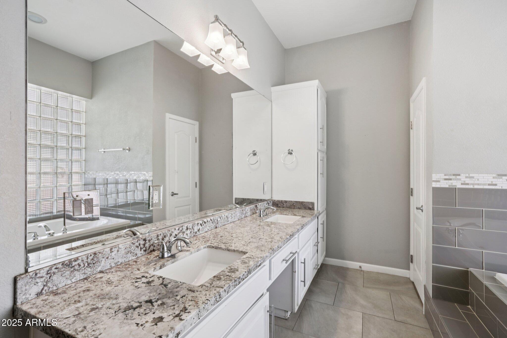 702 West Why Worry Lane Phoenix, AZ 85021 - Photo 20 of 46 a bathroom with a granite countertop sink a mirror and shower