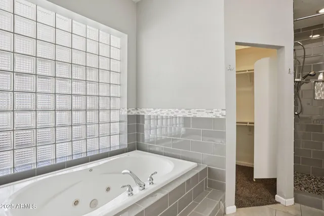 an empty room with chandelier fan and windows