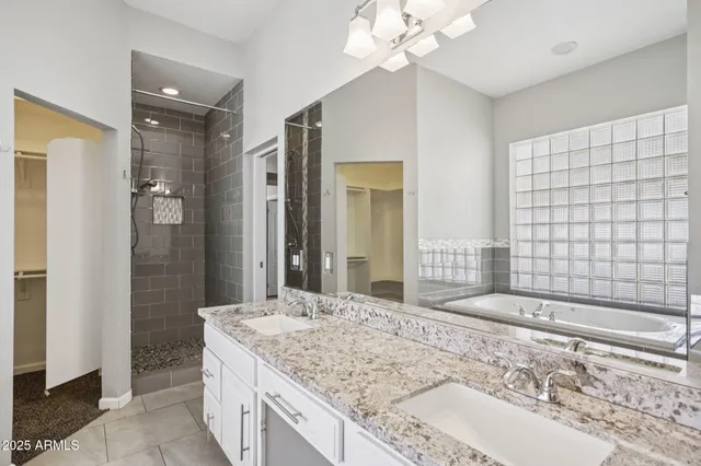 a bathroom with a granite countertop sink a mirror and shower