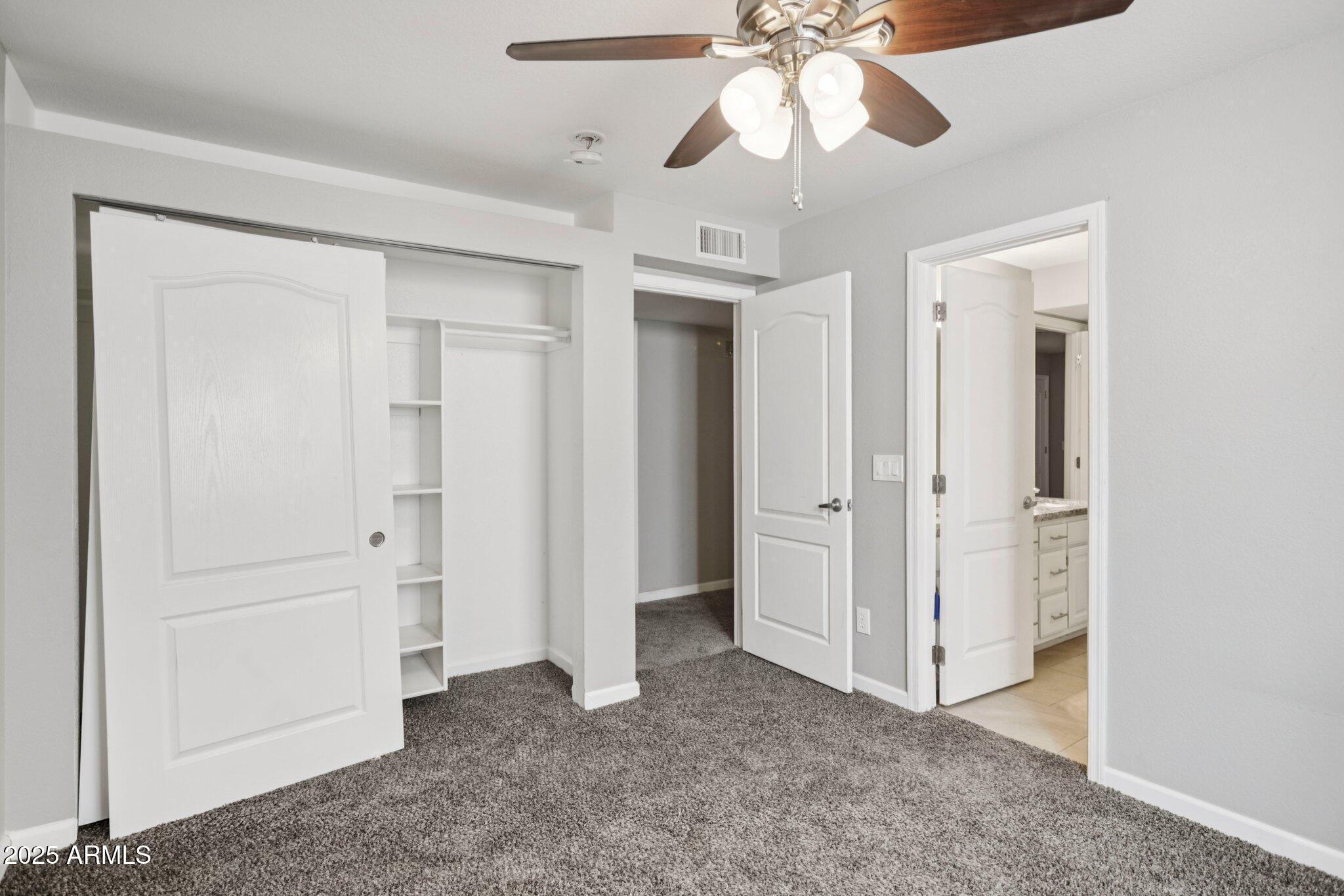 702 West Why Worry Lane Phoenix, AZ 85021 - Photo 32 of 46 a view of a room with closet and a ceiling fan