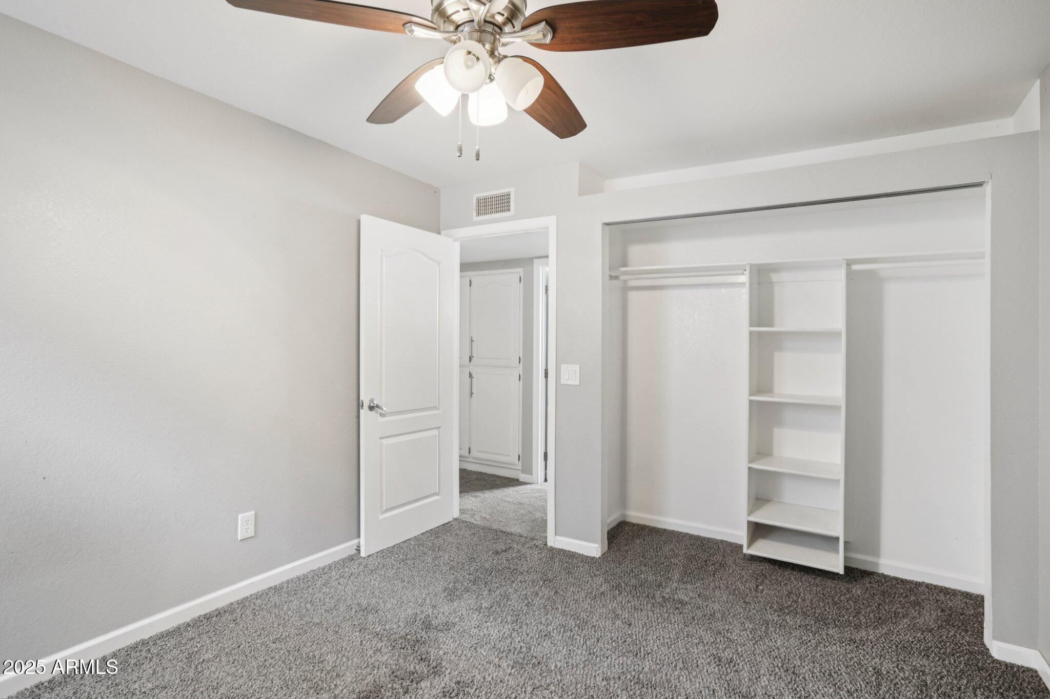 702 West Why Worry Lane Phoenix, AZ 85021 - Photo 34 of 46 an empty room with closet and a chandelier fan